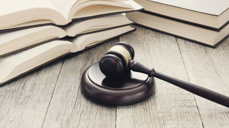 کتاب های قانون تقسیم ارث و چکش عدالت روی میز قرار دارند
