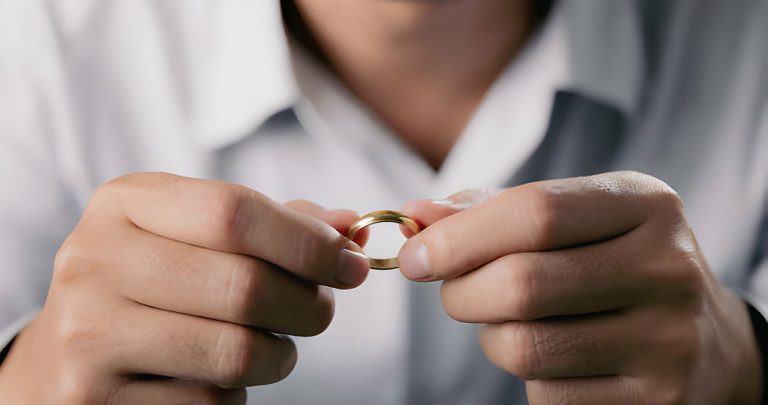 مرد حلقه ازدواج را با دو دست خود نگه داشته است و خواهان طلاق غیابی است